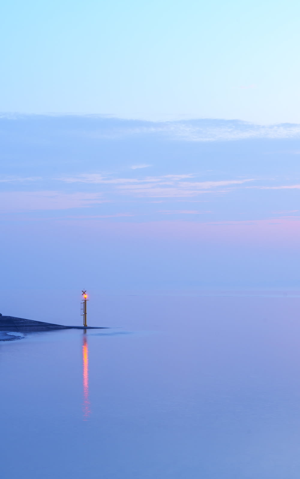 a lone light house in the middle of the ocean
