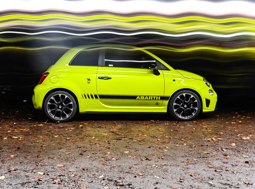 a cute lime green car parked in front of a tunnel