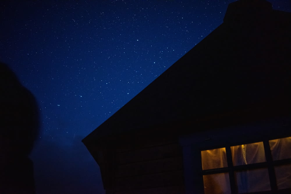 the night sky with stars above a building