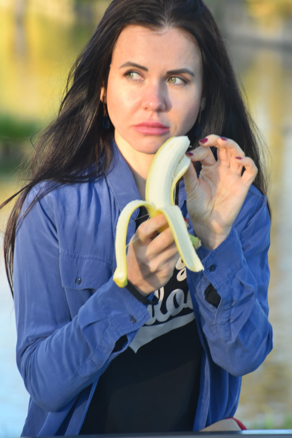 a woman holding a banana up to her face