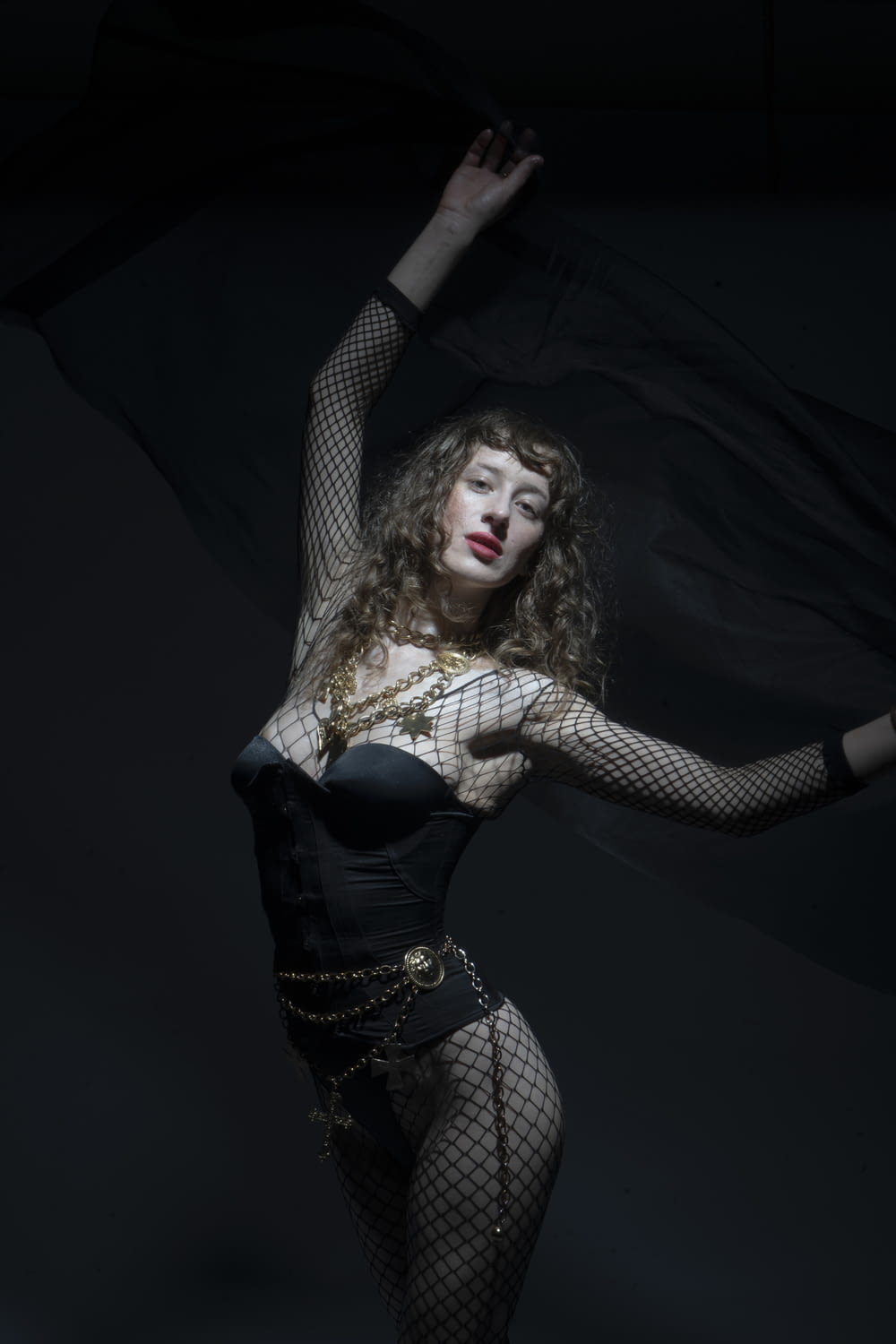 a woman in a fishnet bodysuit and fishnet stockings