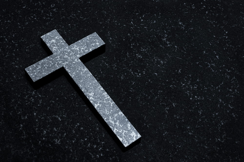 a silver cross on a black background