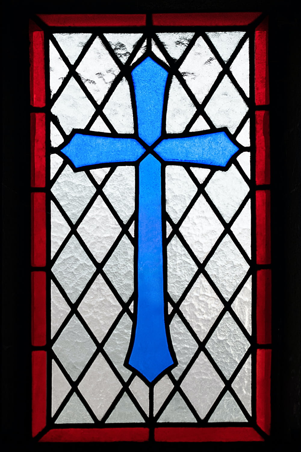 a stained glass window with a blue cross on it