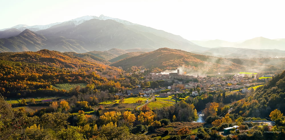 a scenic view of a town surrounded by mountains