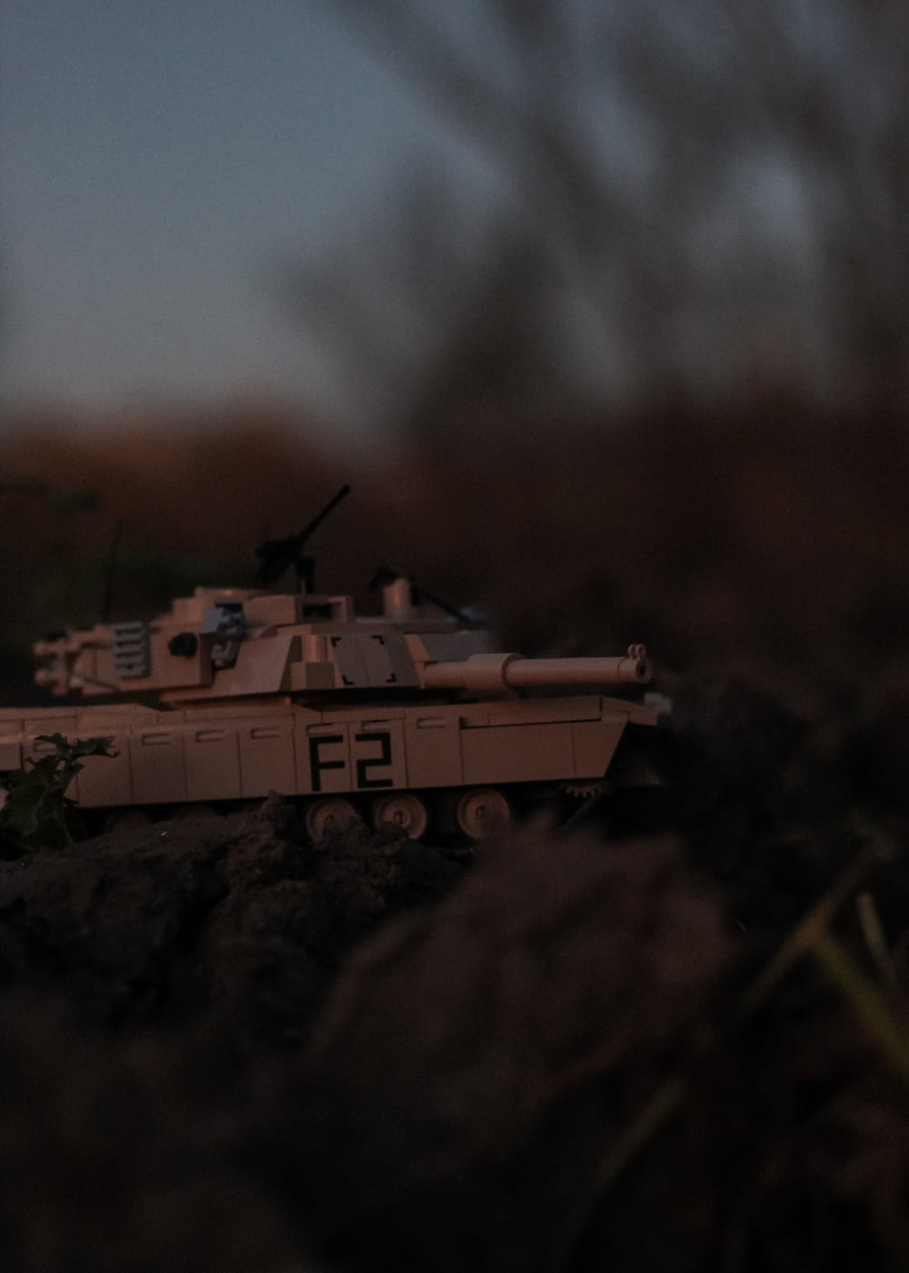 a toy tank sitting on top of a pile of dirt