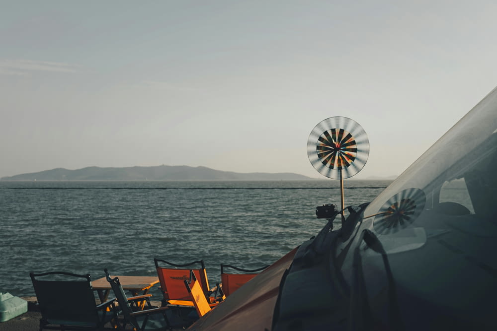 a windmill sitting on top of a boat next to the ocean