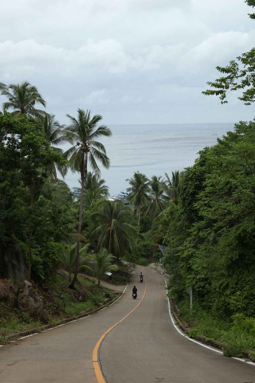 a motorcycle riding down a road next to the ocean