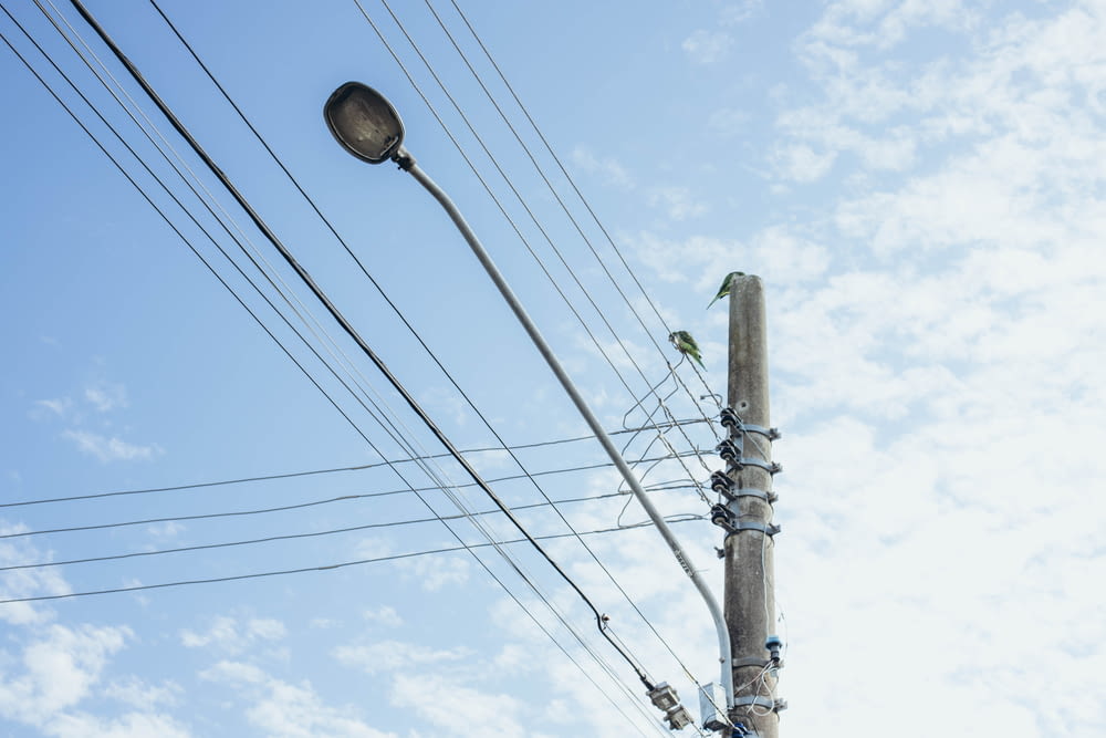 a street light and power lines against a blue sky