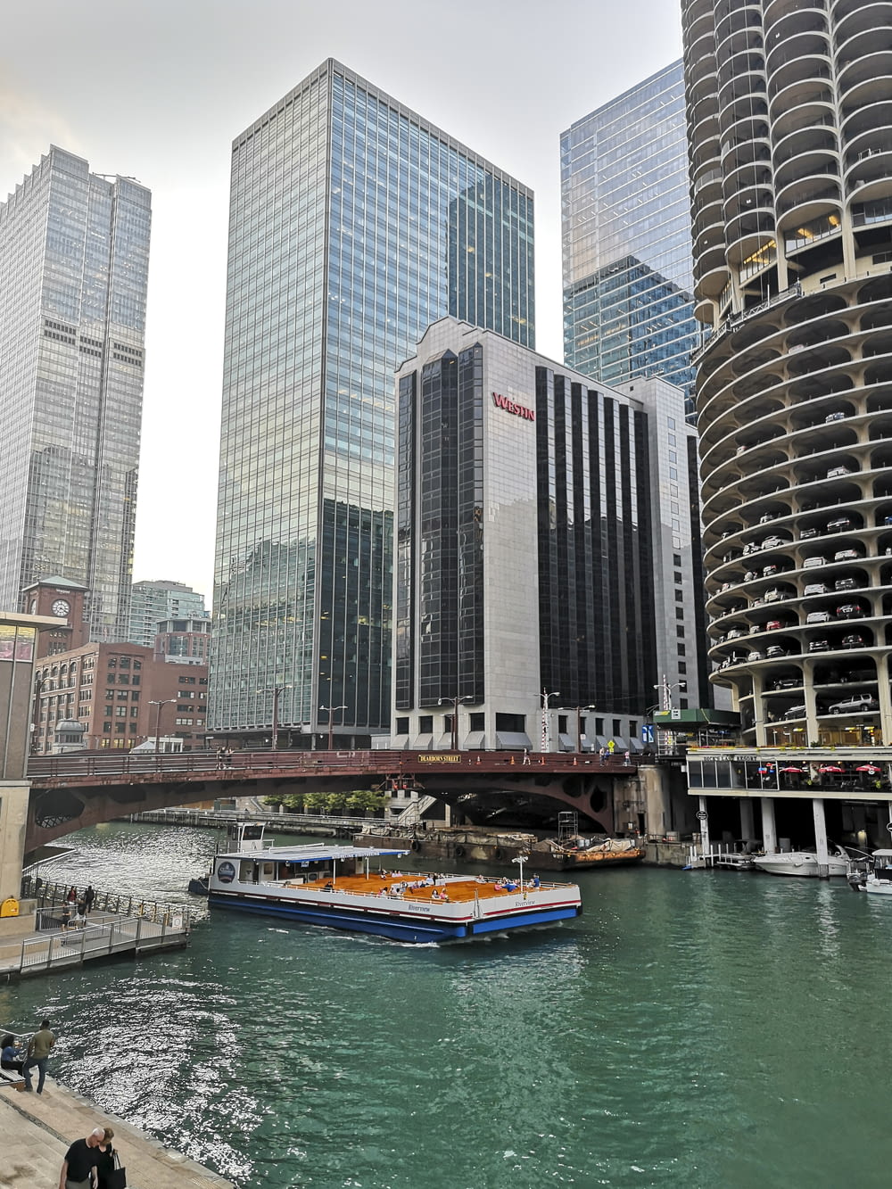 a boat traveling down a river next to tall buildings