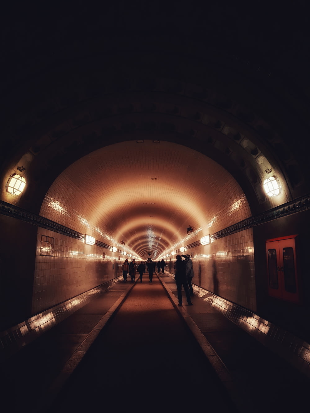 un gruppo di persone che camminano attraverso un tunnel