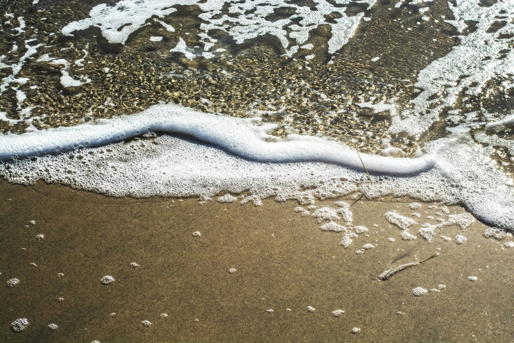 eine Welle, die an das Ufer eines Strandes kommt