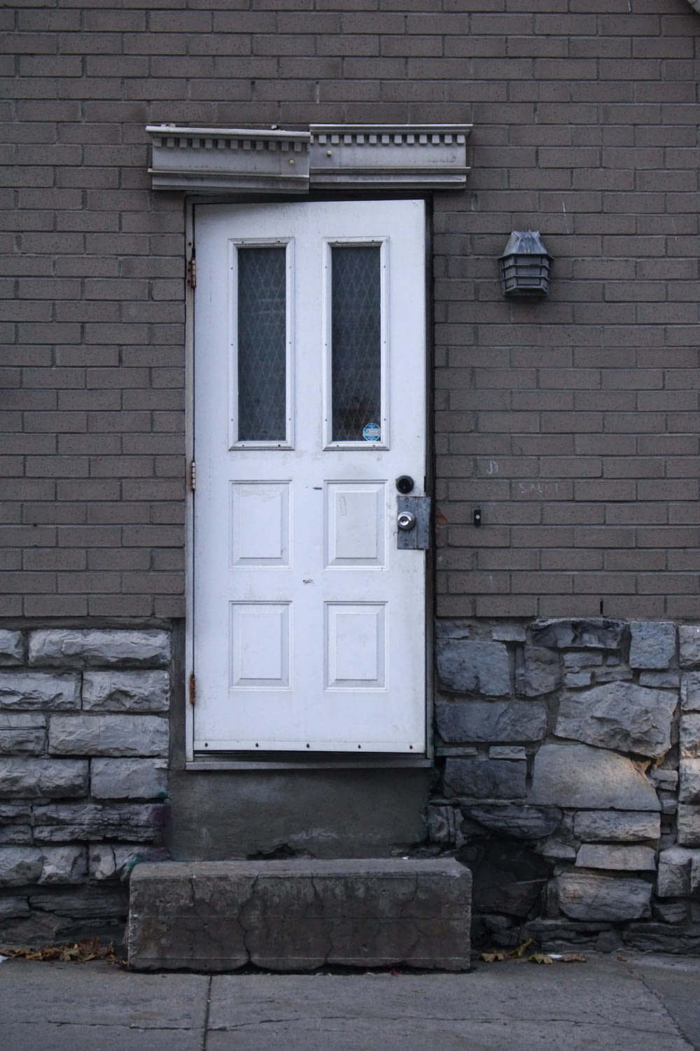 eine weiße Tür, die an der Seite eines Backsteingebäudes sitzt