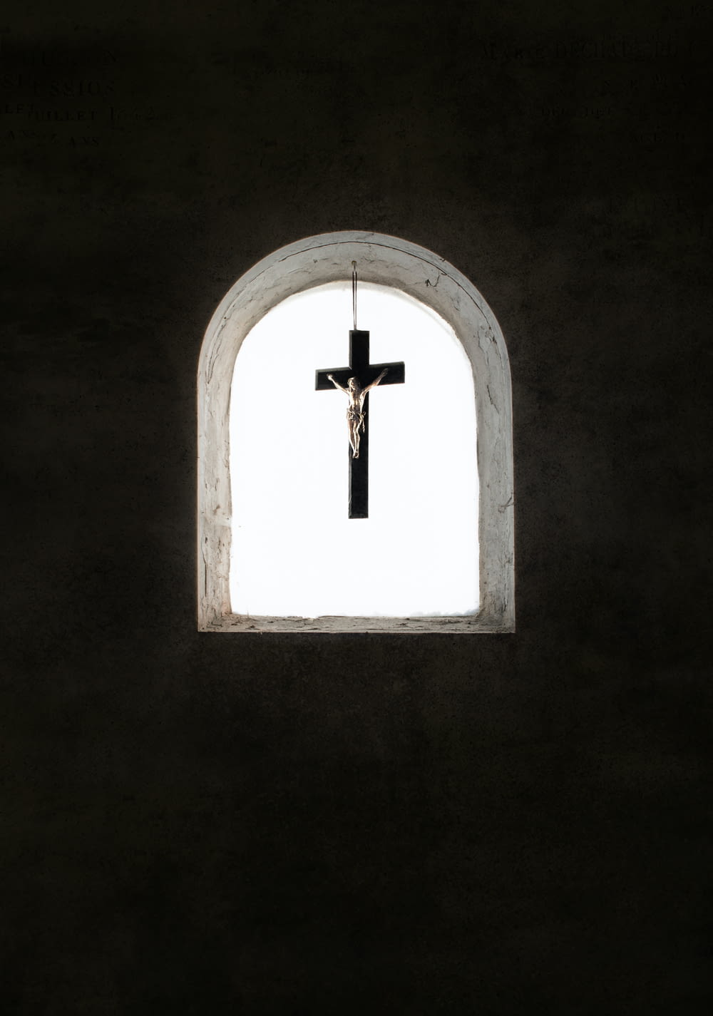 a cross hanging from the side of a wall