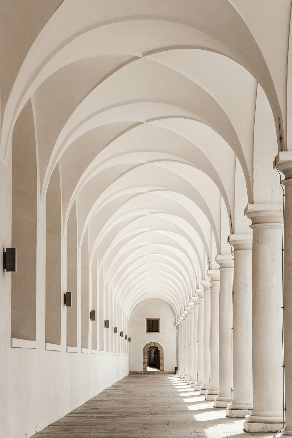 a long hallway with arches and columns on both sides