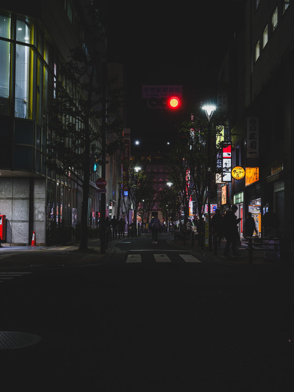 una strada cittadina di notte con un semaforo rosso