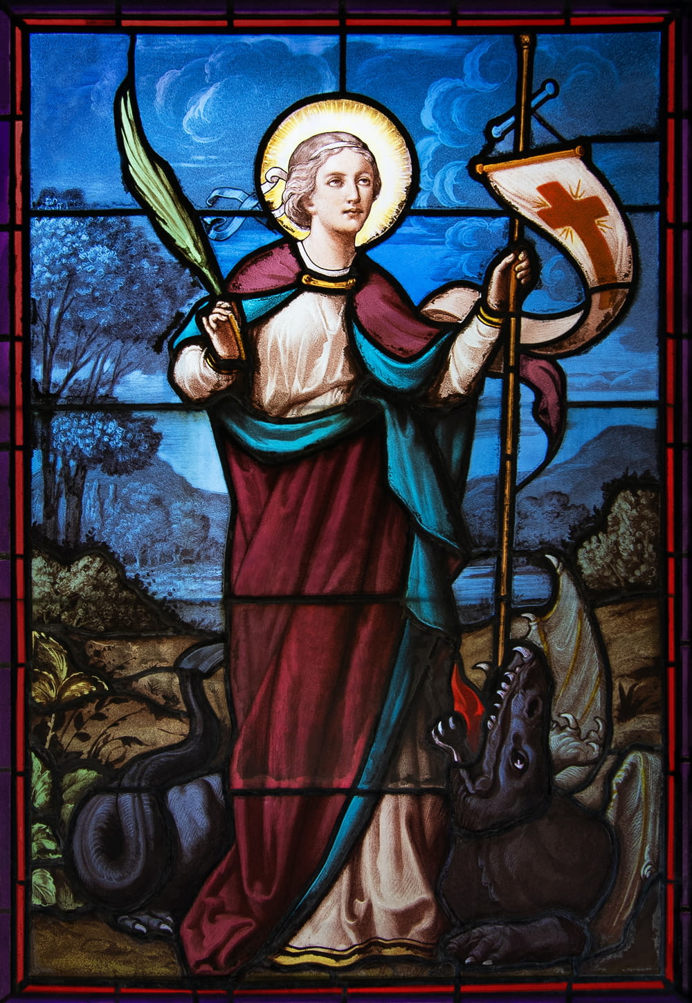 a stained glass window with a woman holding a flag