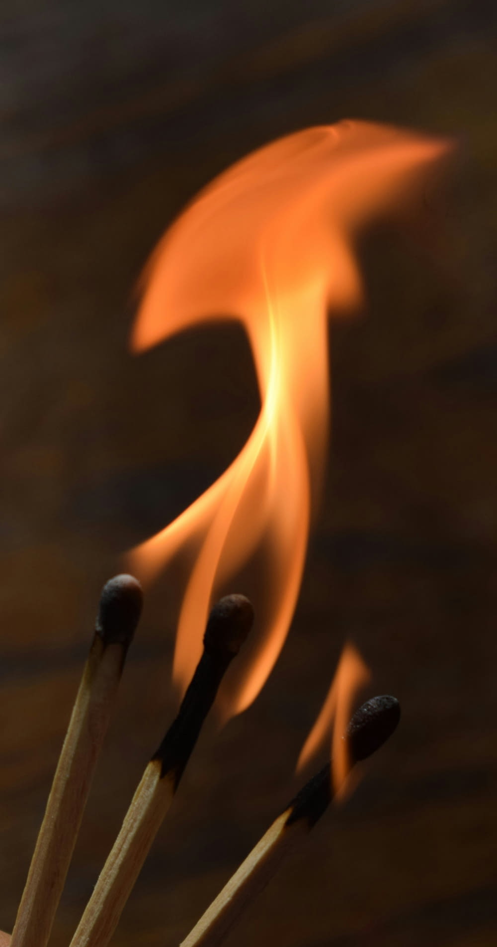 um close up de fósforos com uma chama ao fundo