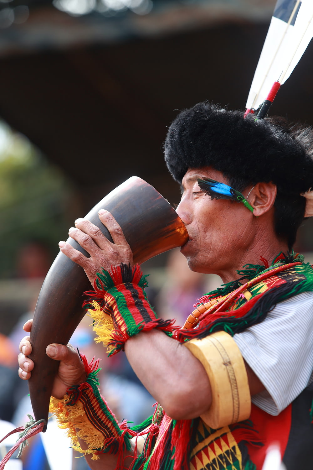 a man in a native american costume drinking from a cup