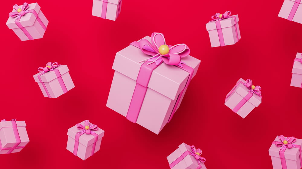 une boîte cadeau rose avec un noeud rose sur fond rouge