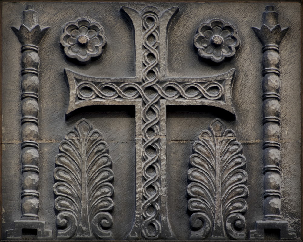 a decorative cross on the side of a building