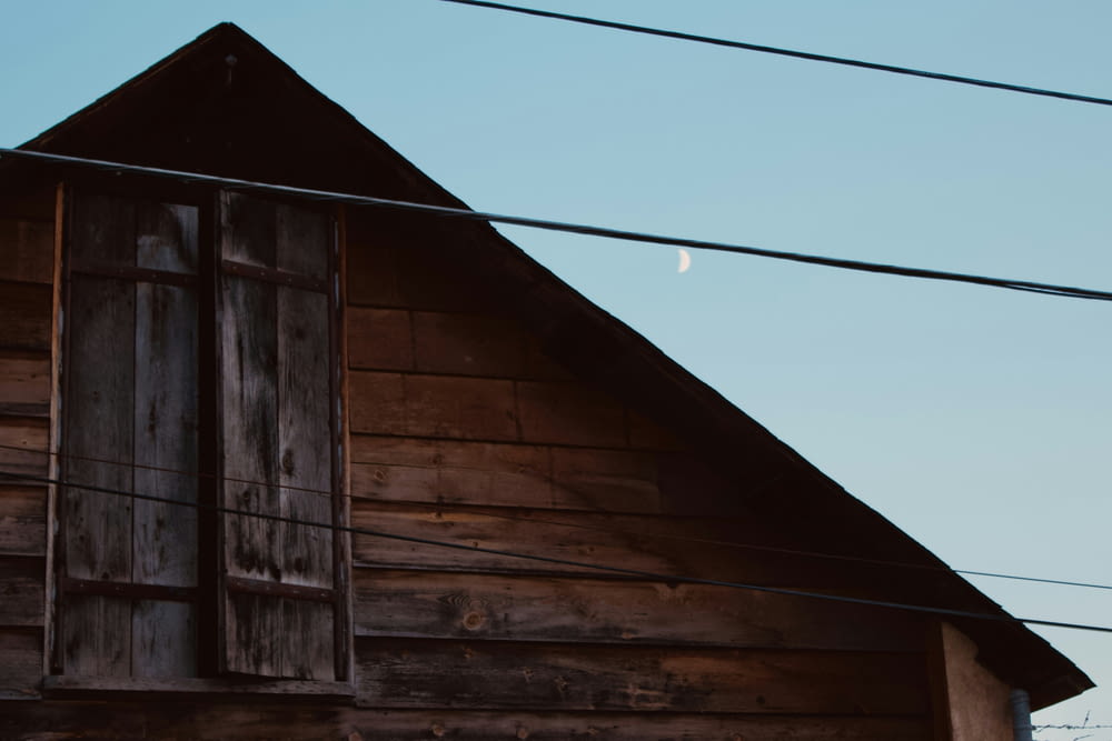 an old wooden building with a half moon in the sky