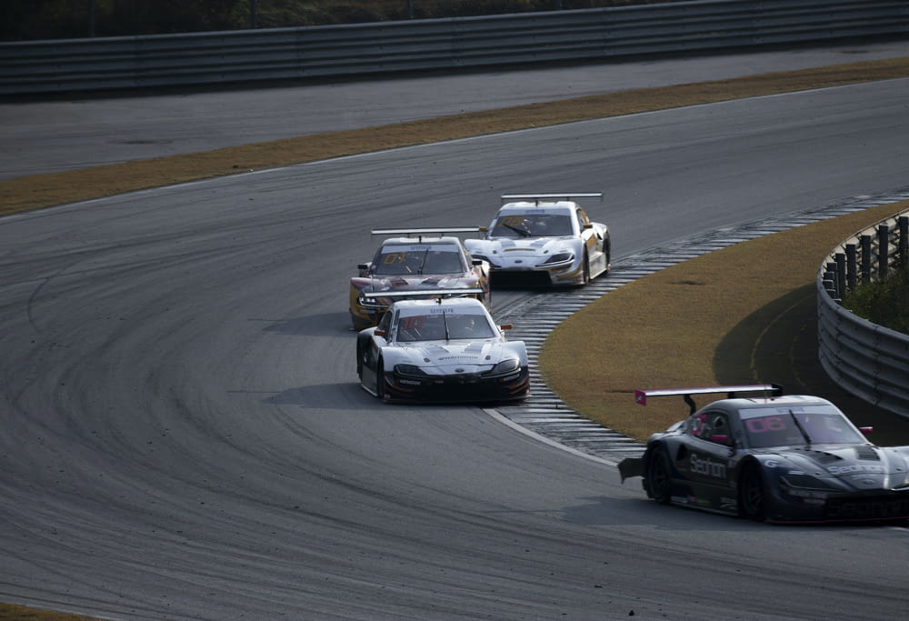 a group of race cars driving around a track
