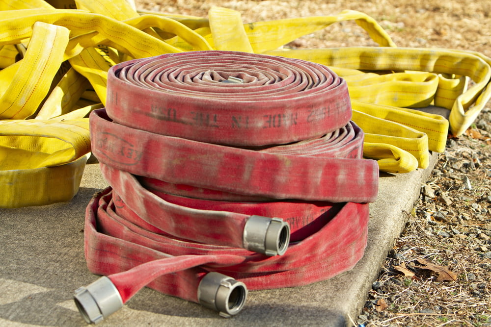 a pile of fire hoses sitting on top of a cement slab