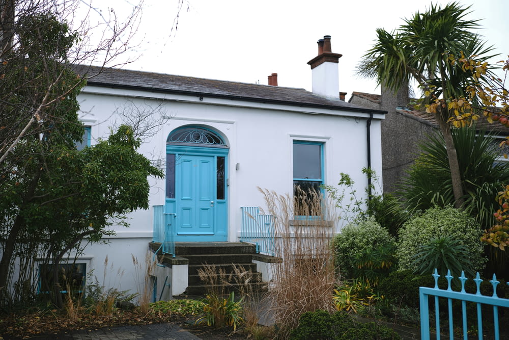 ein weißes Haus mit blauer Eingangstür