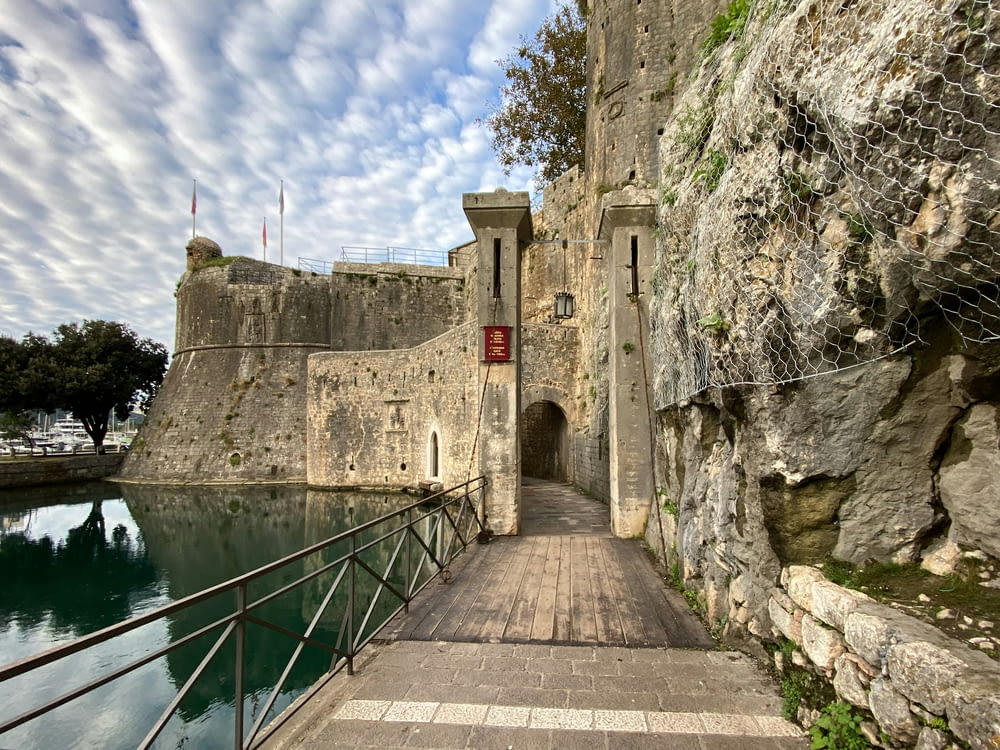 a walkway leading to a castle next to a body of water