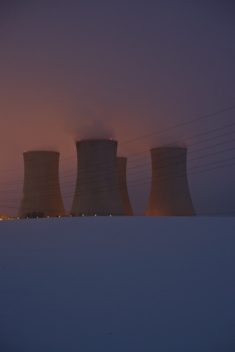 a group of cooling towers in the snow