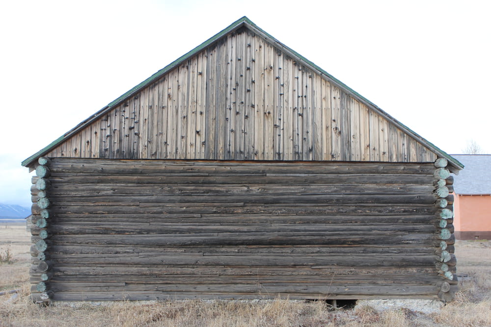 un vecchio edificio in legno in mezzo a un campo