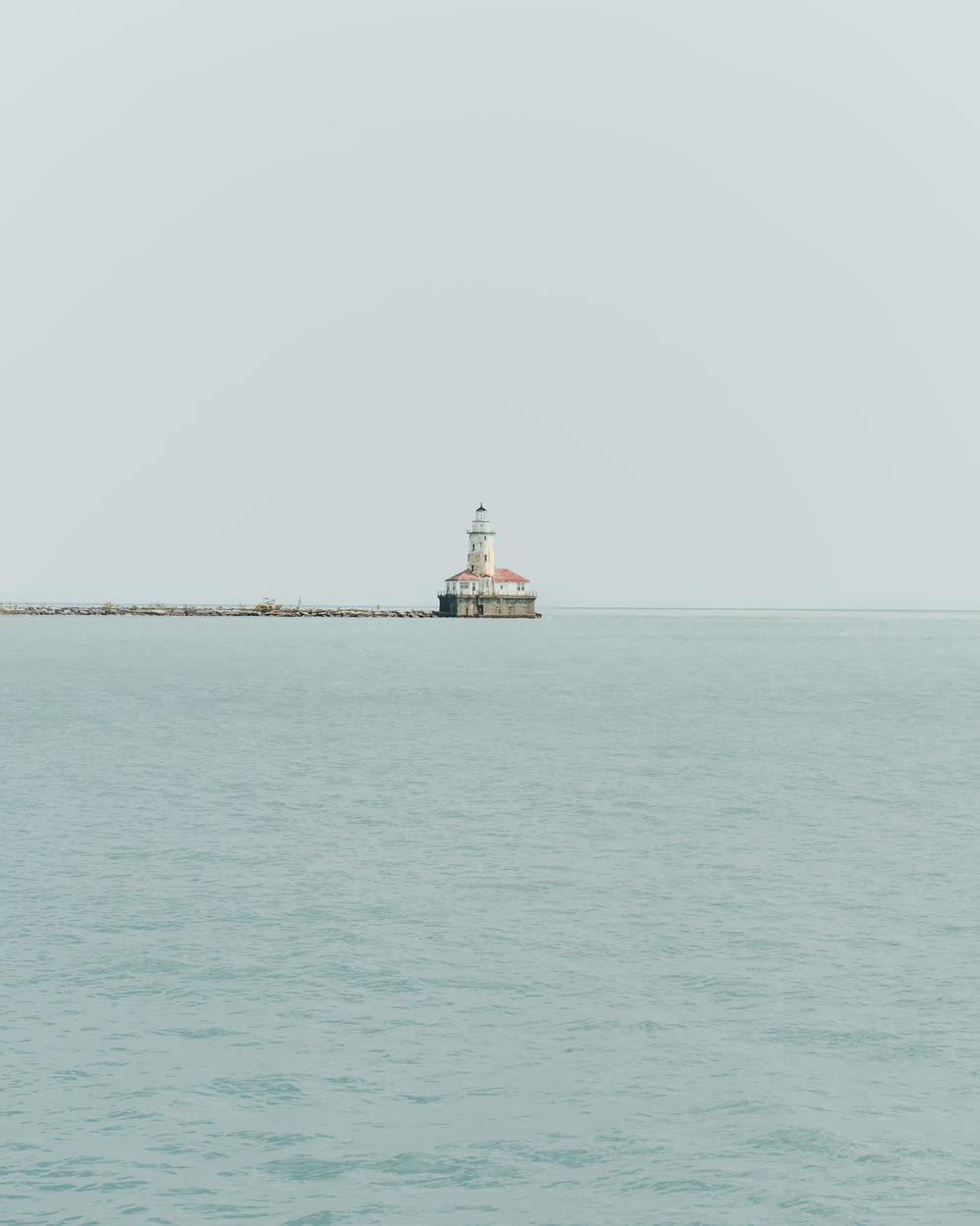 a light house sitting on top of a long pier
