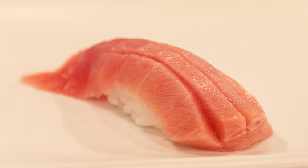 a piece of sushi sitting on top of a white plate