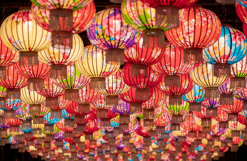 a bunch of colorful lanterns hanging from the ceiling