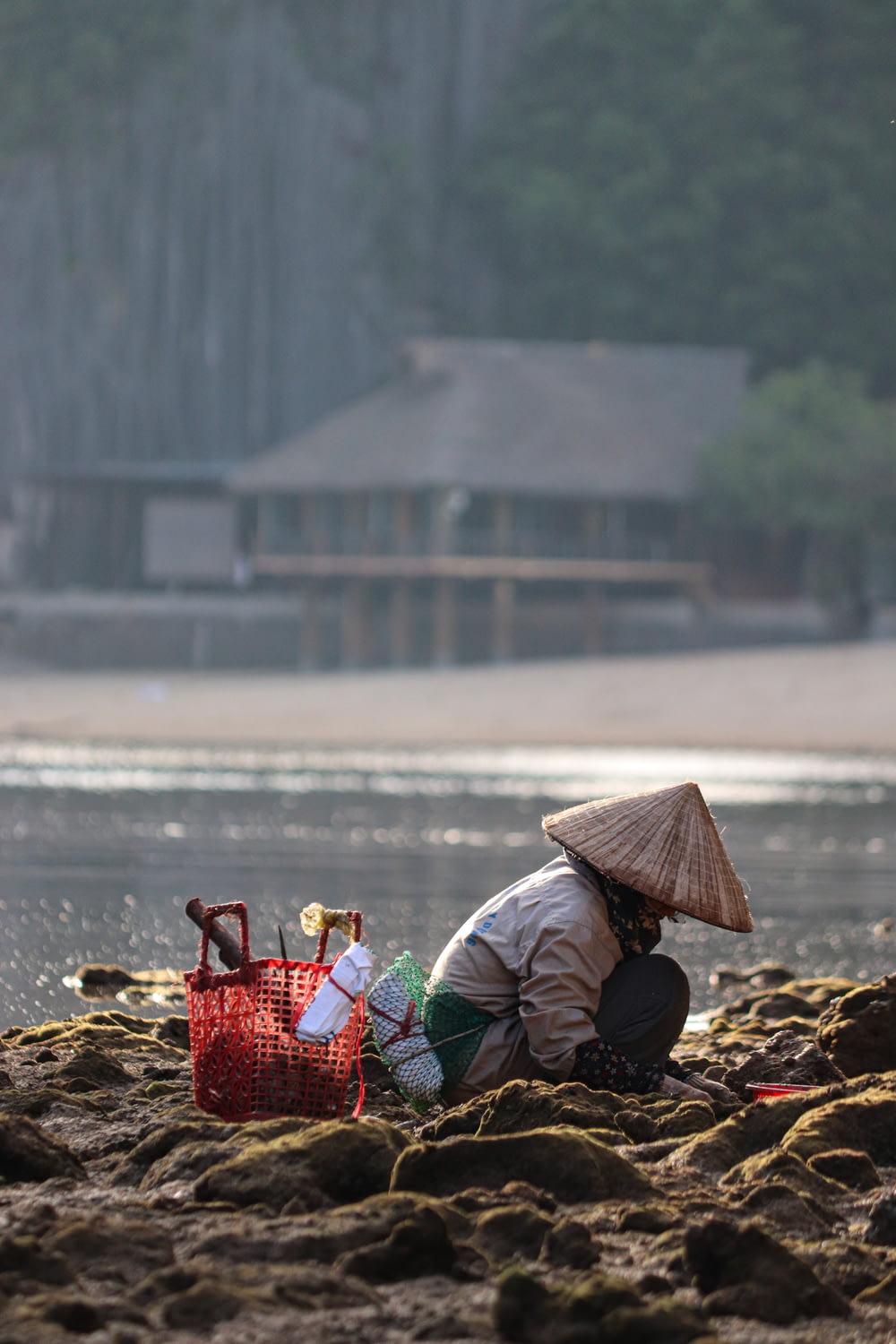 una persona seduta su una spiaggia con un cesto