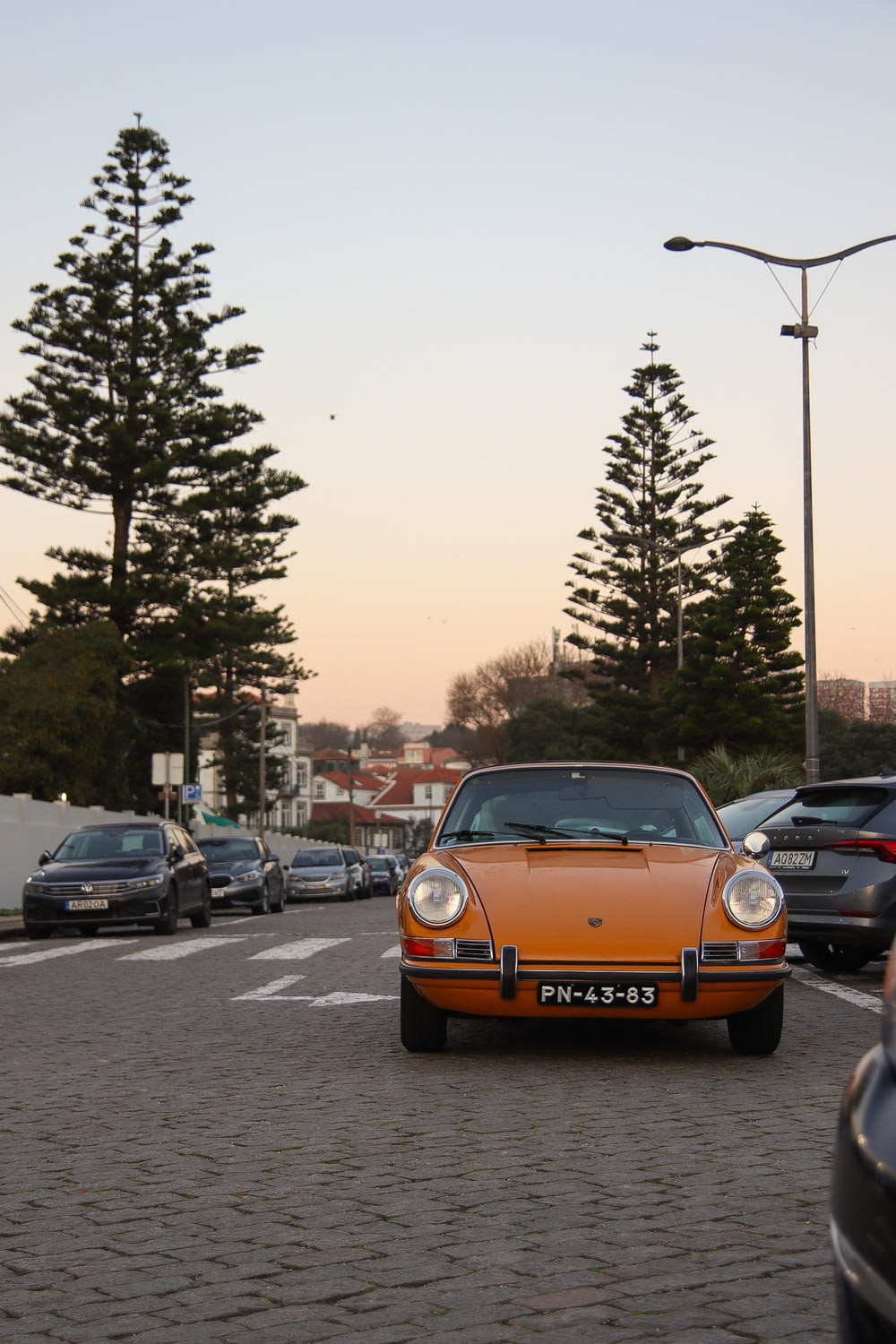 an orange car is parked in a parking lot
