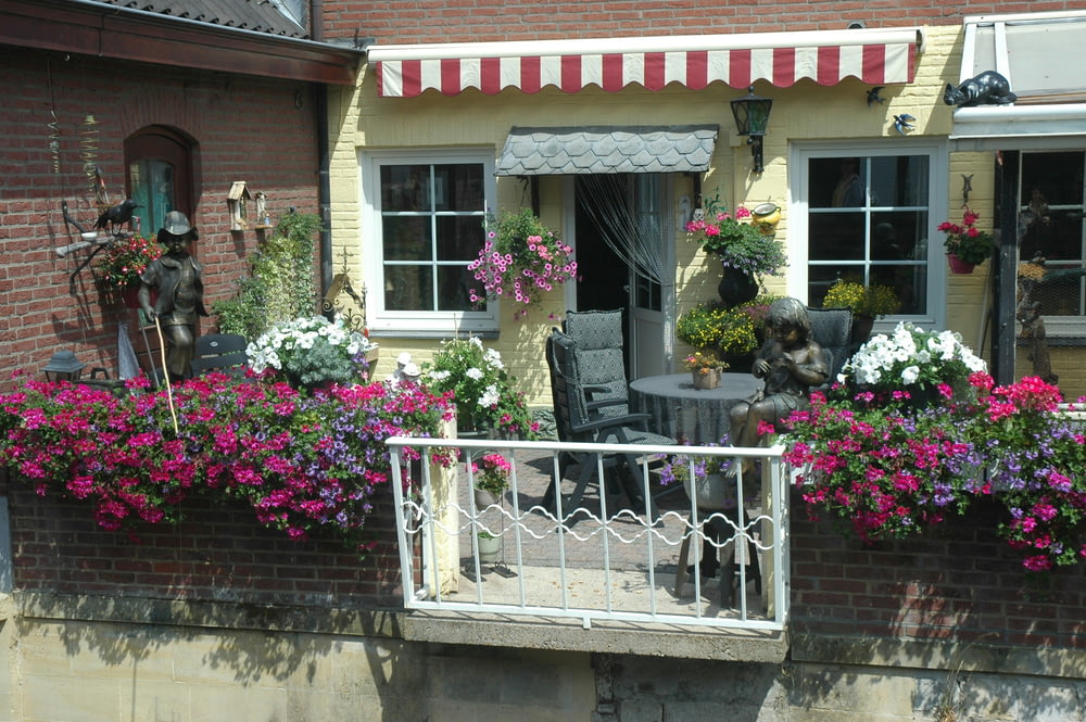a balcony with a table and chairs covered in flowers