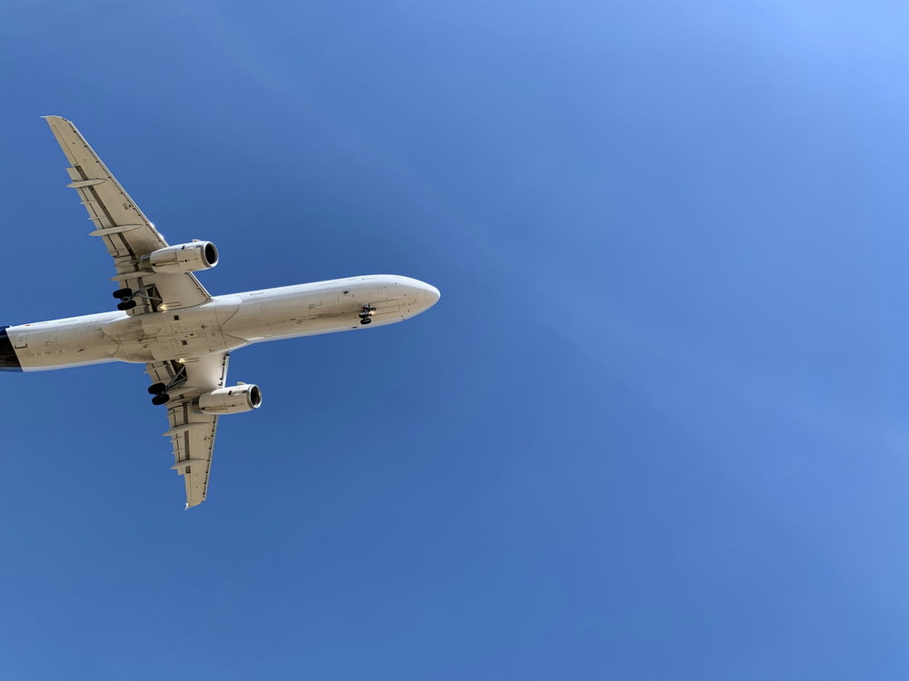 ein großes Düsenflugzeug, das durch einen blauen Himmel fliegt