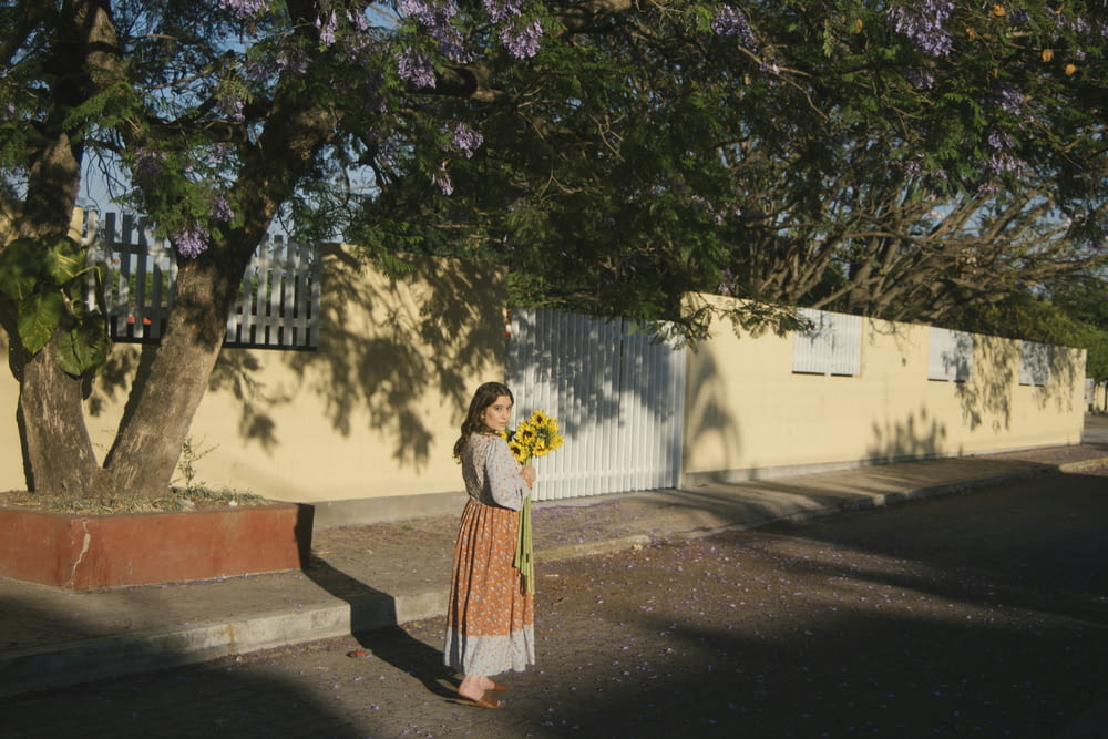 a woman holding a bouquet of flowers on a street