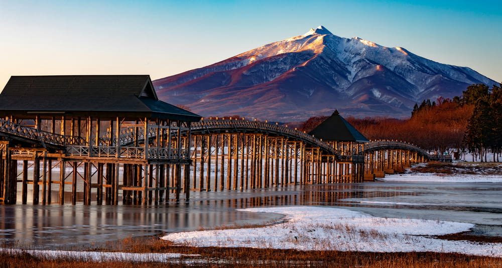 a wooden pier with a mountain in the background