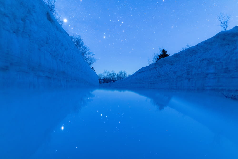a body of water with a sky full of stars