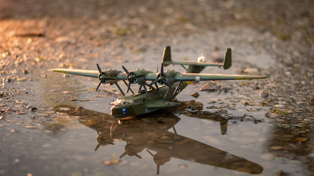a model airplane sitting on top of a puddle of water