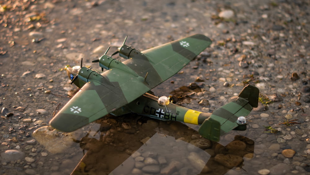 a toy airplane sitting on top of a puddle of water