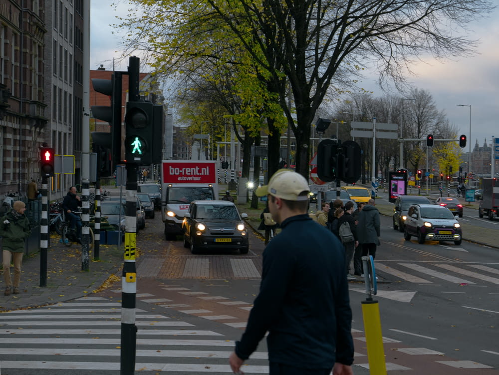 a man walking across a street next to a traffic light