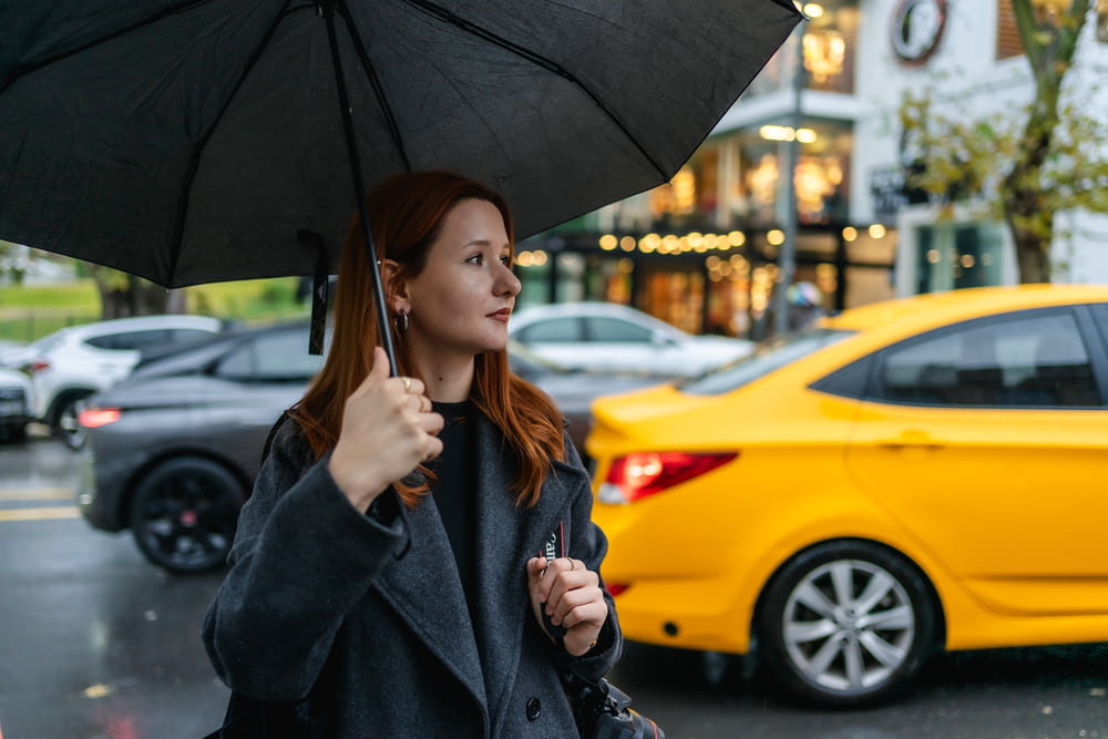 a woman holding an umbrella on a city street