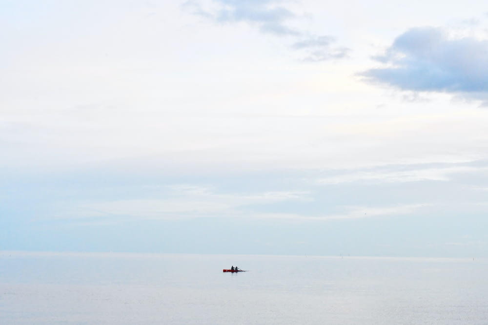 大きな水域の真ん中に浮かぶ孤独なボート