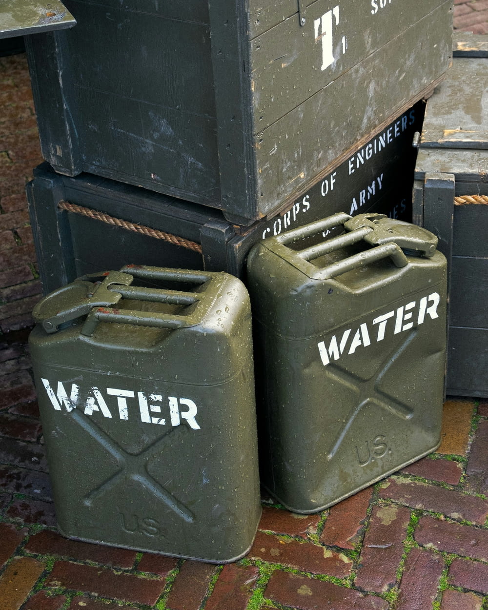 a couple of green containers sitting on top of a brick floor