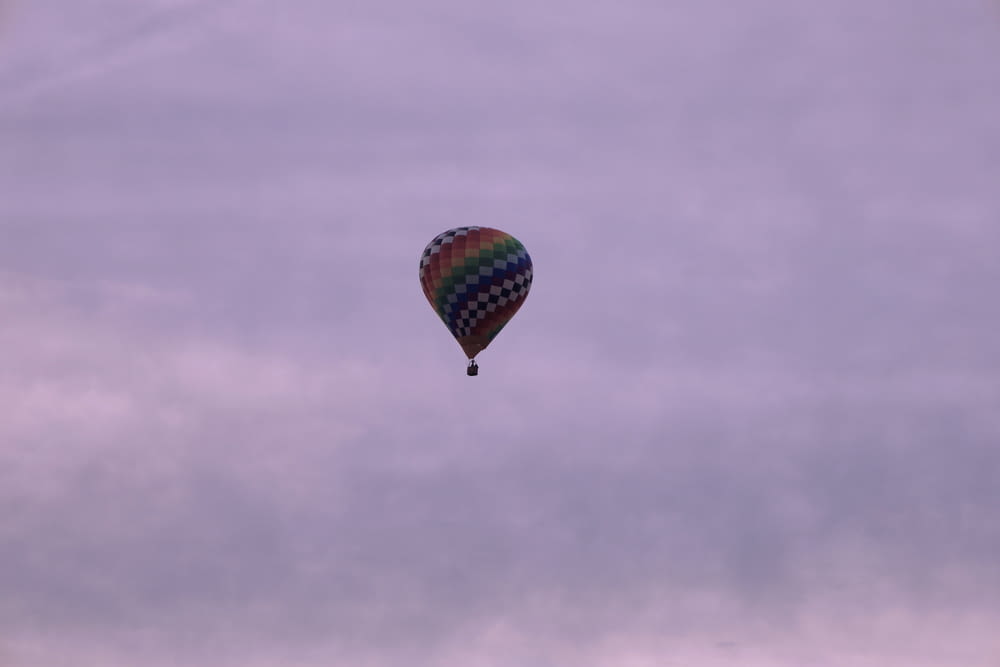 ein bunter Heißluftballon, der durch einen bewölkten Himmel fliegt