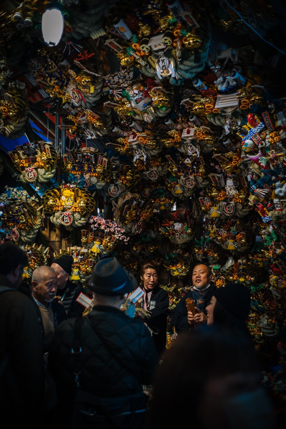 a group of people standing in front of a wall of stuffed animals