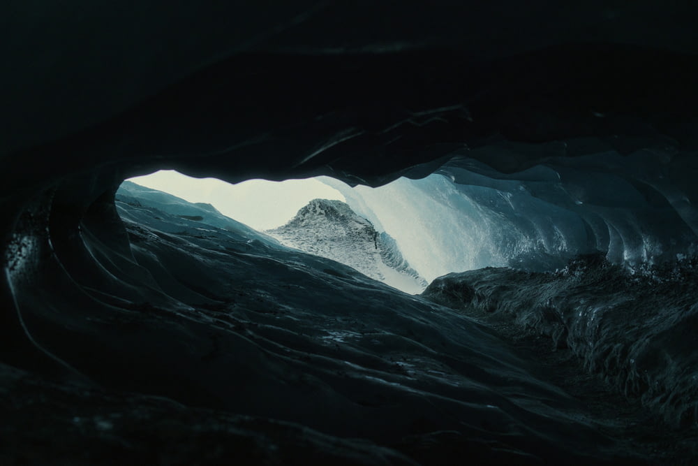 a large ice cave with a mountain in the distance